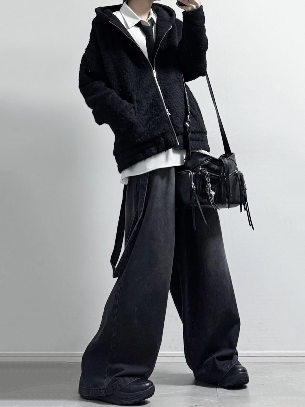 ブラック系のパーカー、ホワイト系のシャツ/ブラウス、グレー系のデニムパンツを着用したメンズの秋コーディネートの1枚目の写真