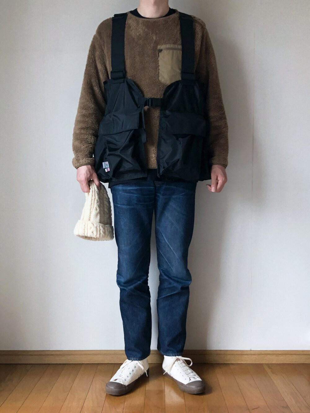 「ニット帽、ニットキャップ、ケーブルニット、ENGINEERED GARMENTS、フリース、ユニクロ、ケーブル編み、ハイカットスニーカー、ローテクスニーカー、白キャップ、バトルレイク、ゲームベスト、STOP 誹謗中傷」｜「BATTLE LAKEの＜BATTLE LAKE＞ GAME VEST/ベスト（ベスト、ブラック系）」を使った、となりさん（メンズ・179cm）の秋コーディネートの1枚目の写真
