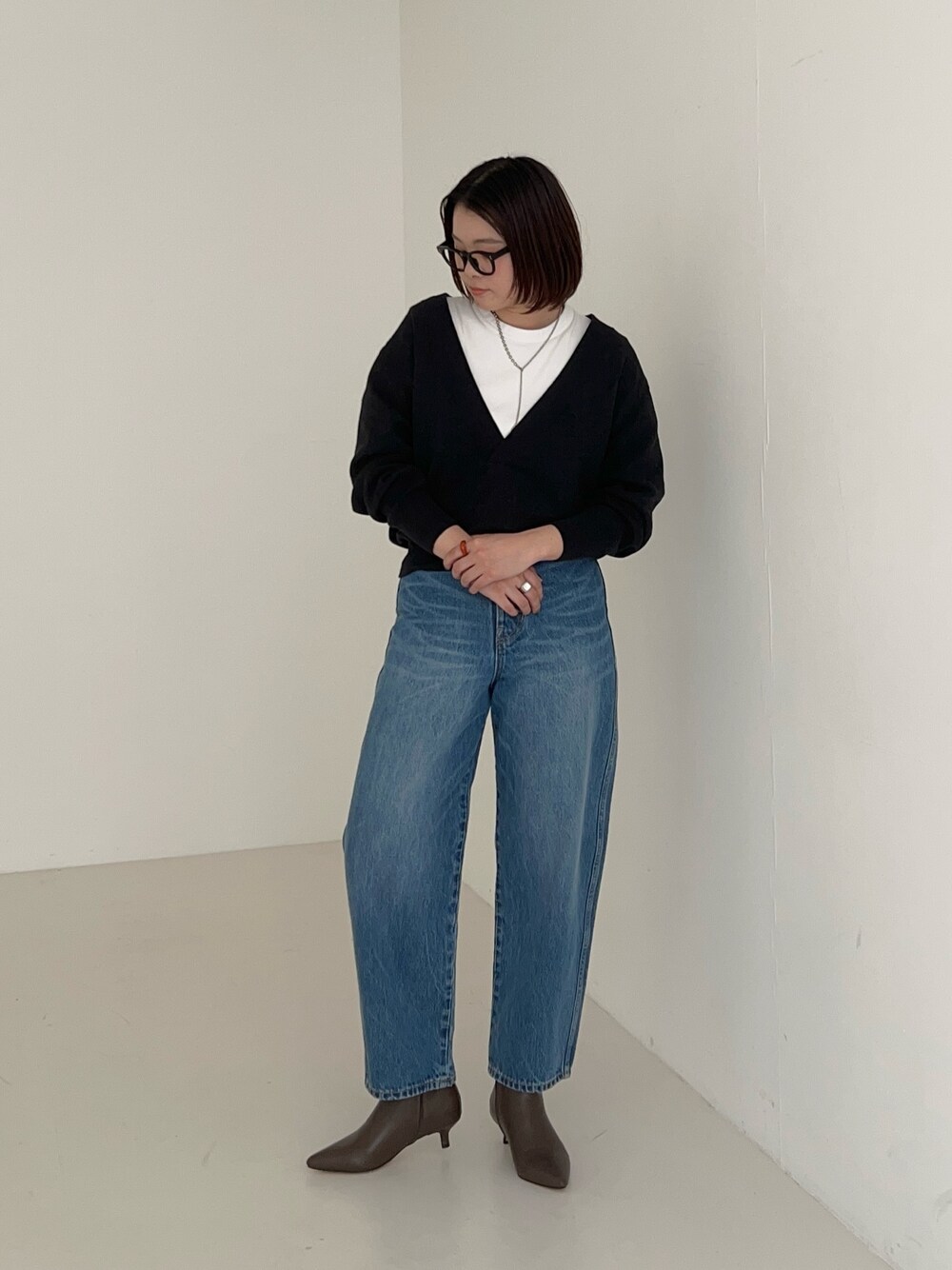 ブルー系のデニムパンツ、グレー系のニット/セーターを着用したレディースの秋コーディネートの1枚目の写真