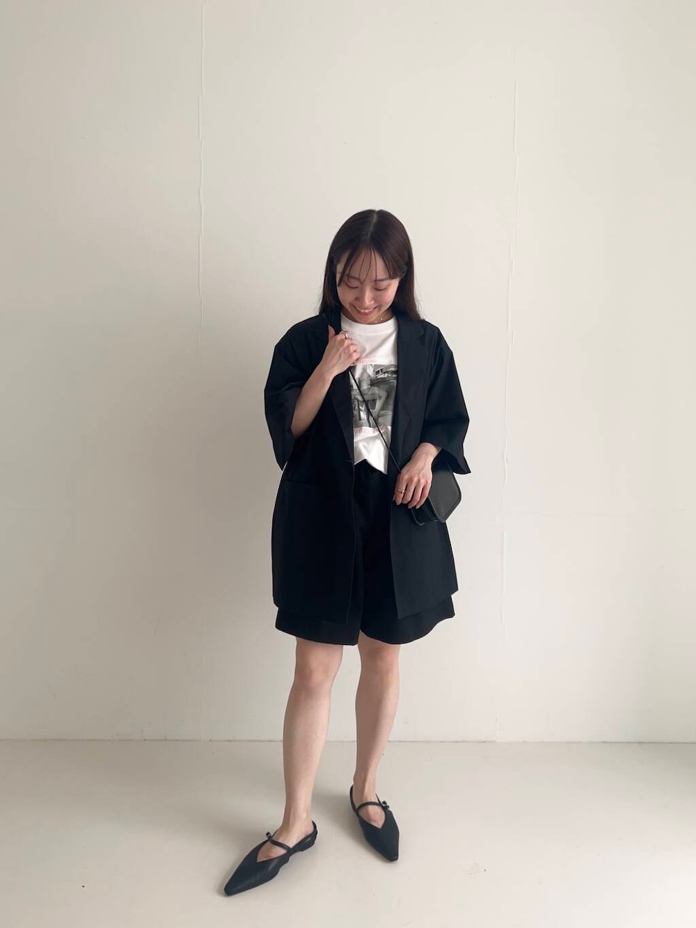 ブラック系のショルダーバッグ、ブラック系のパンプス、ブラック系のその他パンツを着用したレディースの夏コーディネートの1枚目の写真