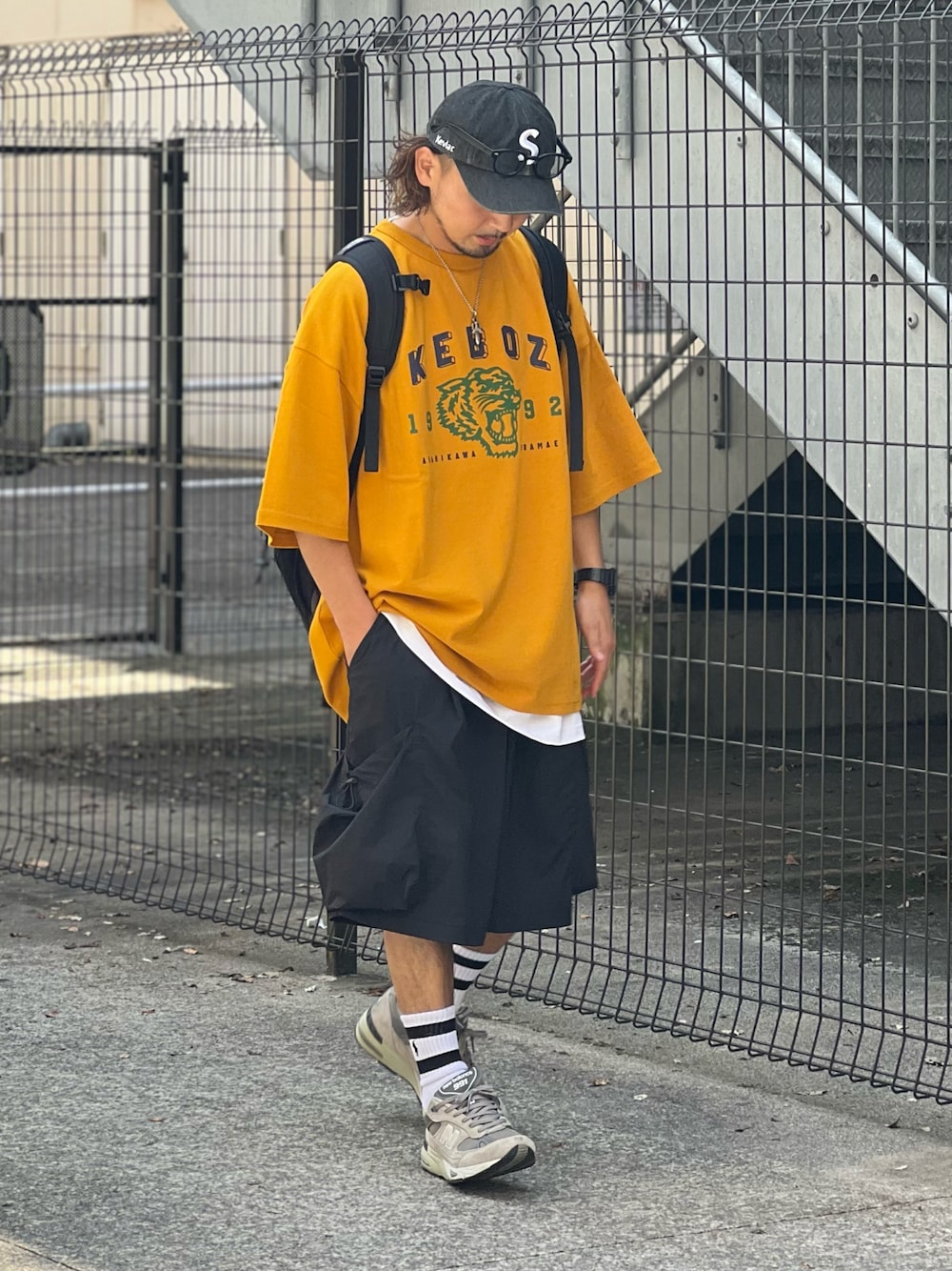 イエロー系のTシャツ/カットソー、ブラック系のパンツ、グレー系のスニーカーを着用したメンズの夏コーディネートの1枚目の写真