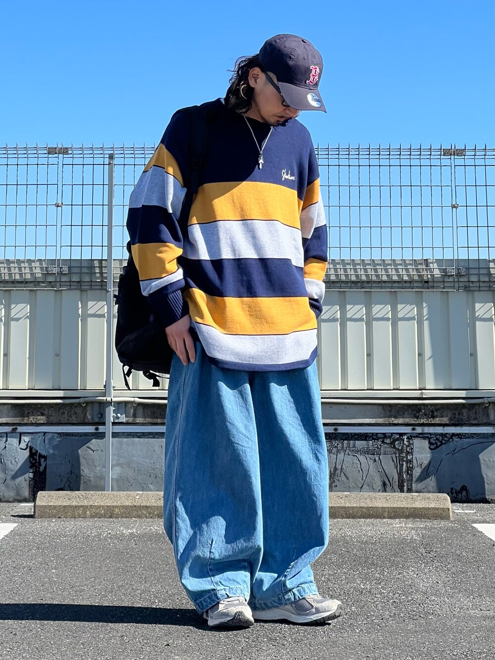 ブルー系のニット/セーター、ブルー系のデニムパンツ、グレー系のスニーカーを着用したメンズの冬コーディネートの1枚目の写真