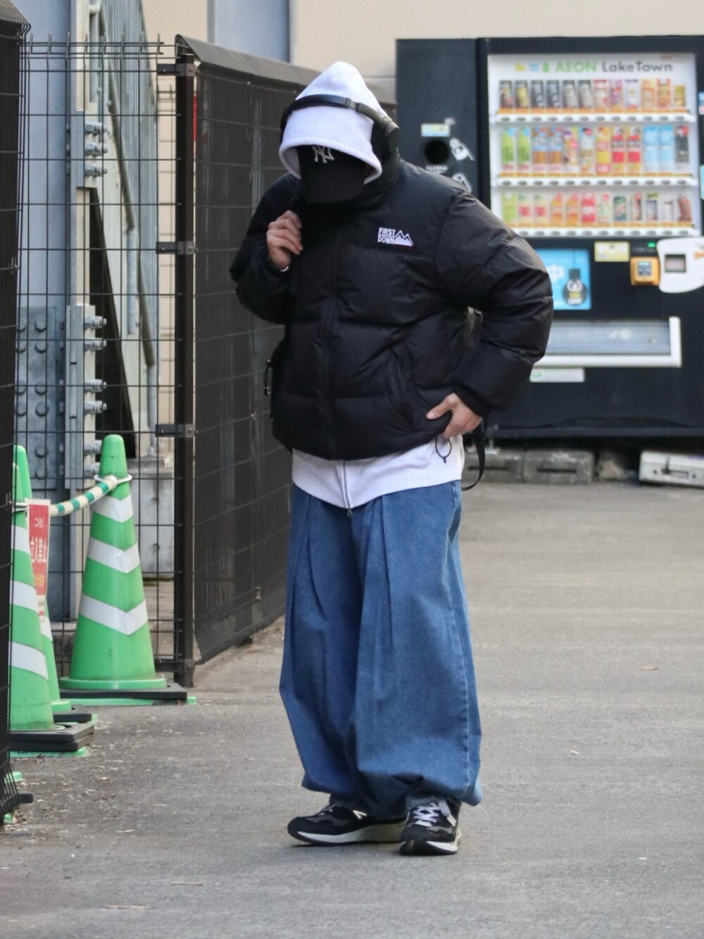 ブラック系のダウンジャケット/コート、グレー系のパーカー、ブルー系のデニムパンツを着用したメンズの冬コーディネートの1枚目の写真