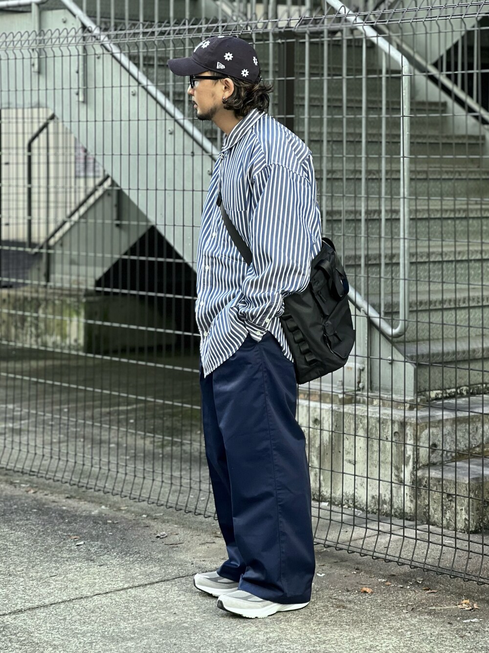 ブルー系のチノパンツ、ブラック系のシャツ/ブラウスを着用したメンズの春コーディネートの1枚目の写真