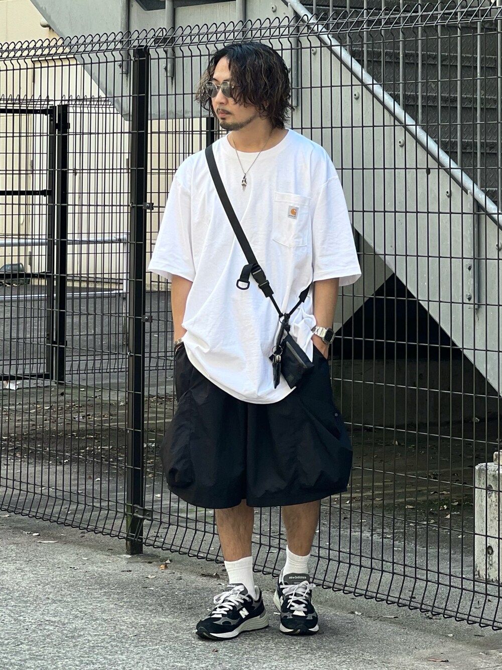 ブラック系のショルダーバッグ、ホワイト系のTシャツ/カットソー、ブラック系のパンツを着用したメンズの夏コーディネートの1枚目の写真