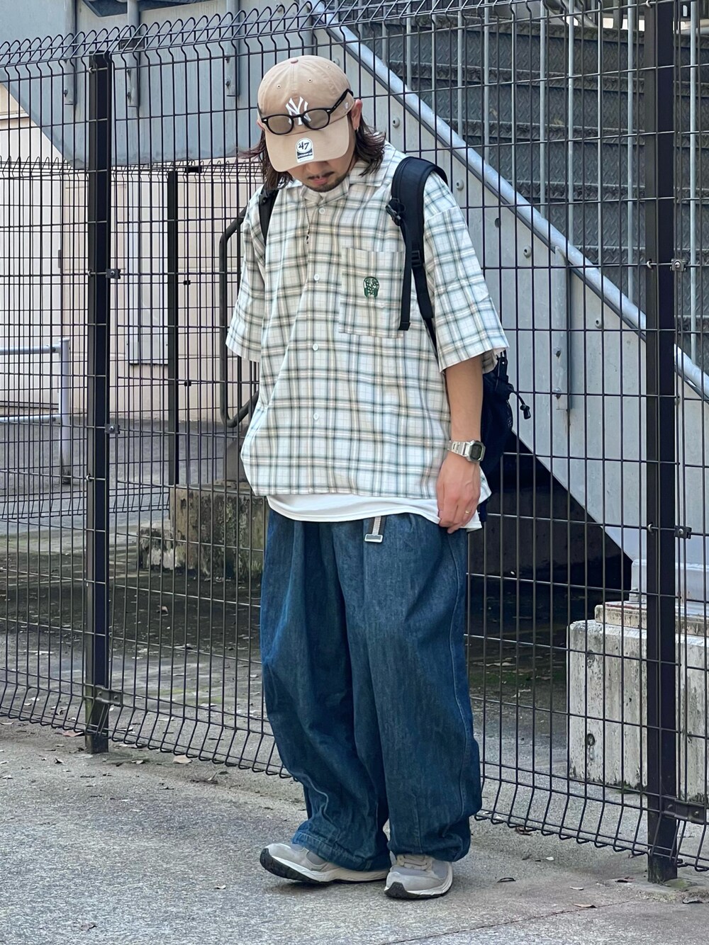 ブルー系のデニムパンツ、グレー系のスニーカー、ホワイト系のシャツ/ブラウスを着用したメンズの夏コーディネートの1枚目の写真
