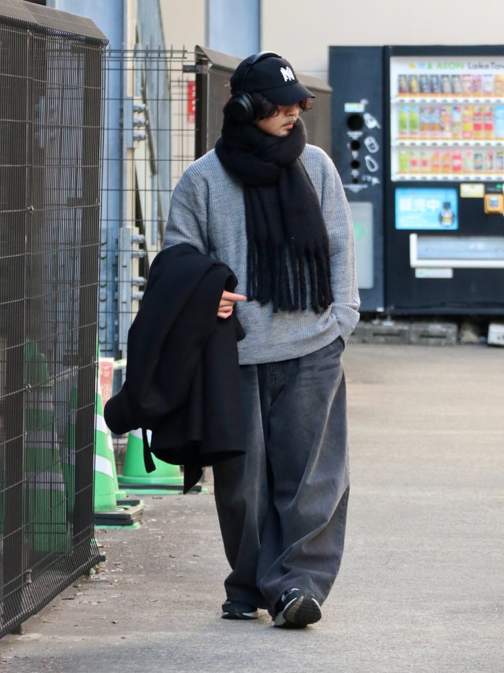 グレー系のニット/セーター、ブラック系のマフラーを着用したメンズの冬コーディネートの1枚目の写真