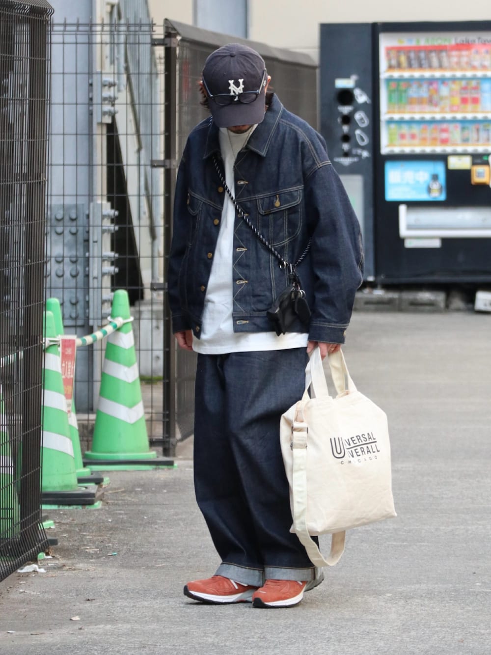 ブルー系のデニムジャケット、ブルー系のデニムパンツ、オレンジ系のスニーカーを着用したメンズの春コーディネートの1枚目の写真