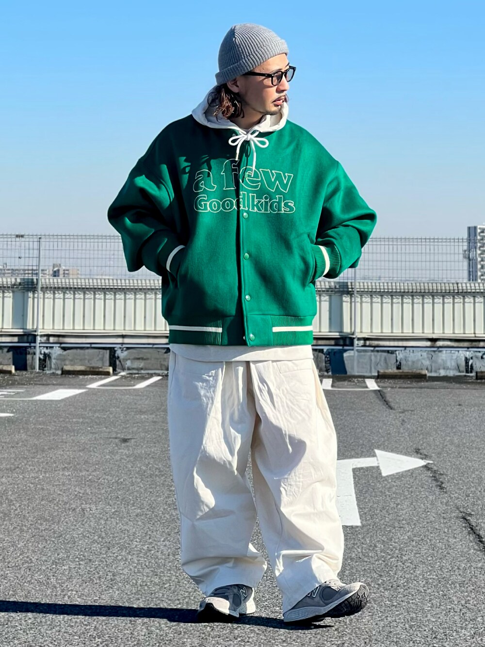 グリーン系のスタジャン、ホワイト系のその他パンツ、グレー系のスニーカーを着用したメンズの冬コーディネートの1枚目の写真