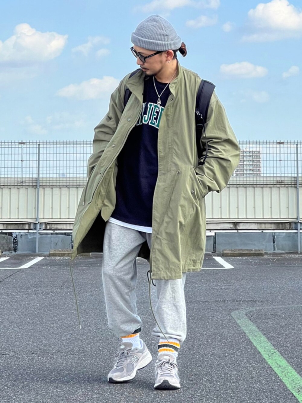 グリーン系のモッズコート、ホワイト系のその他パンツ、ブラック系のTシャツ/カットソーを着用したメンズの秋コーディネートの1枚目の写真