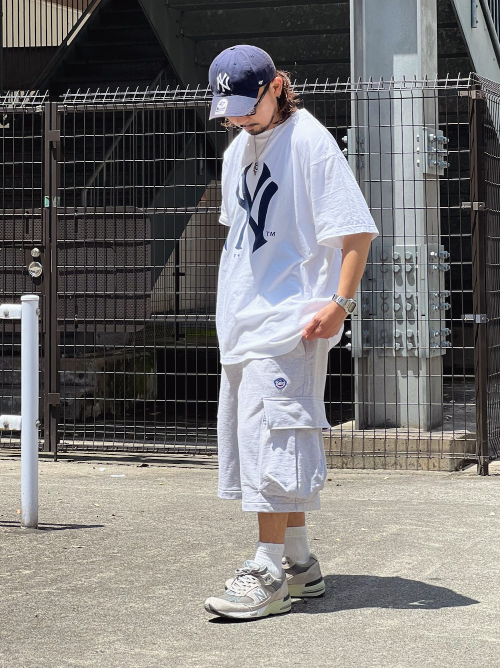 ホワイト系のTシャツ/カットソー、グレー系のパンツ、グレー系のスニーカーを着用したメンズの春コーディネートの1枚目の写真