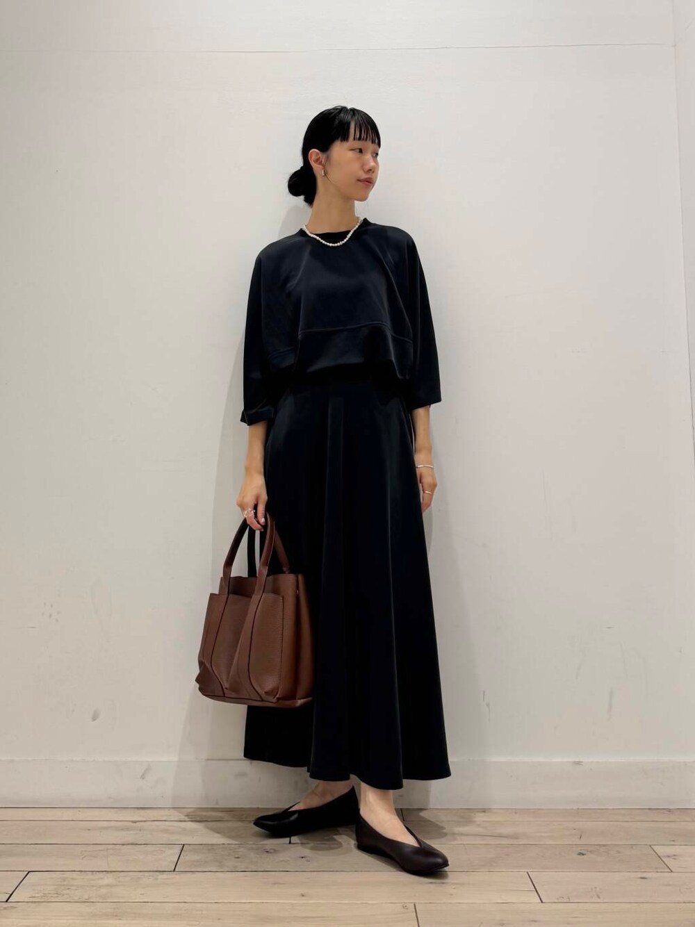 ブラウン系のパンプス、ブラック系のTシャツ/カットソー、ブラック系のスカートを着用したレディースの夏コーディネートの1枚目の写真