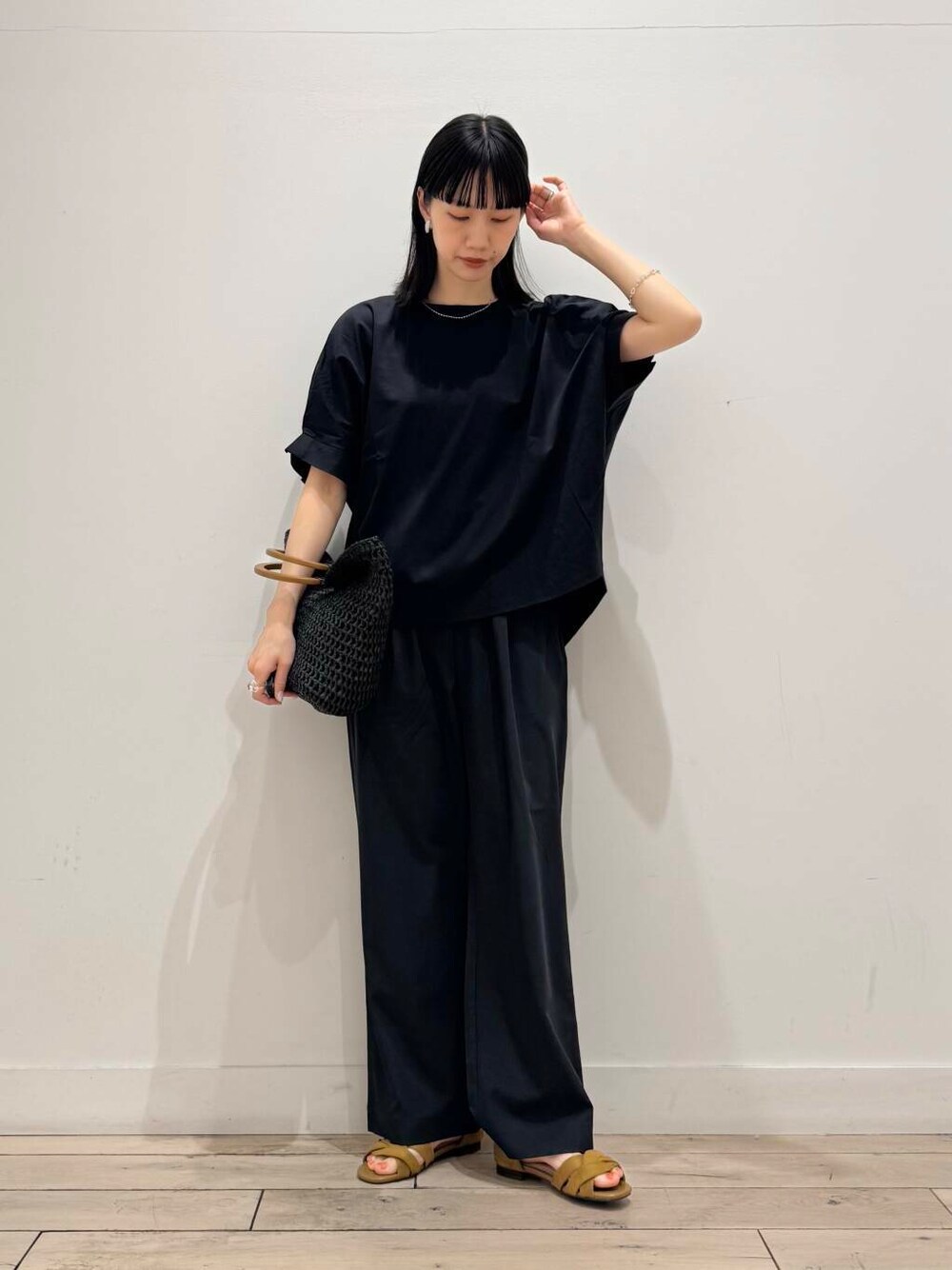 ブラック系のトートバッグ、イエロー系のサンダル、グレー系のその他パンツを着用したレディースの春コーディネートの1枚目の写真