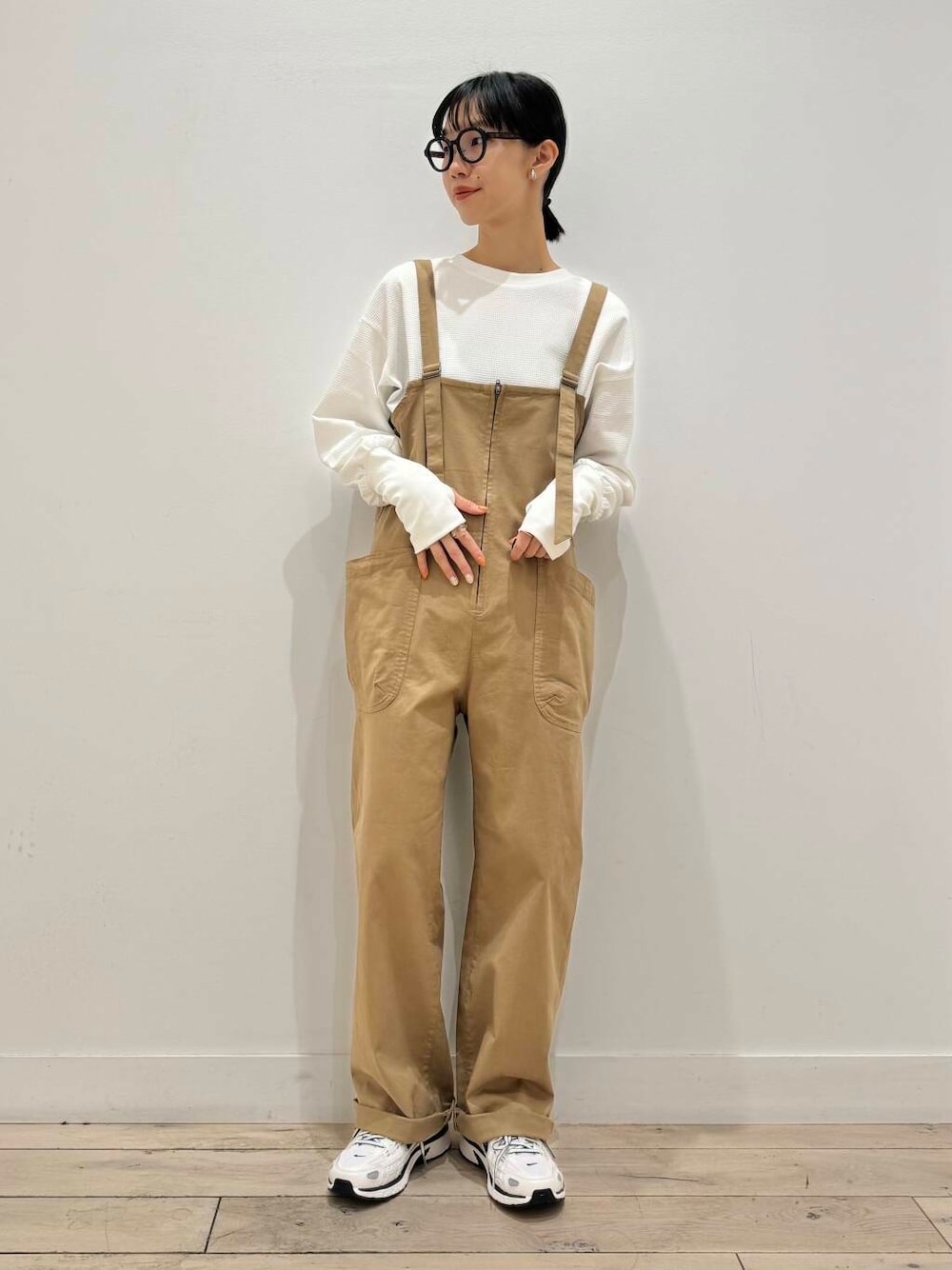 イエロー系のサロペット/オーバーオール、ホワイト系のスニーカー、ホワイト系のTシャツ/カットソーを着用したレディースの秋コーディネートの1枚目の写真