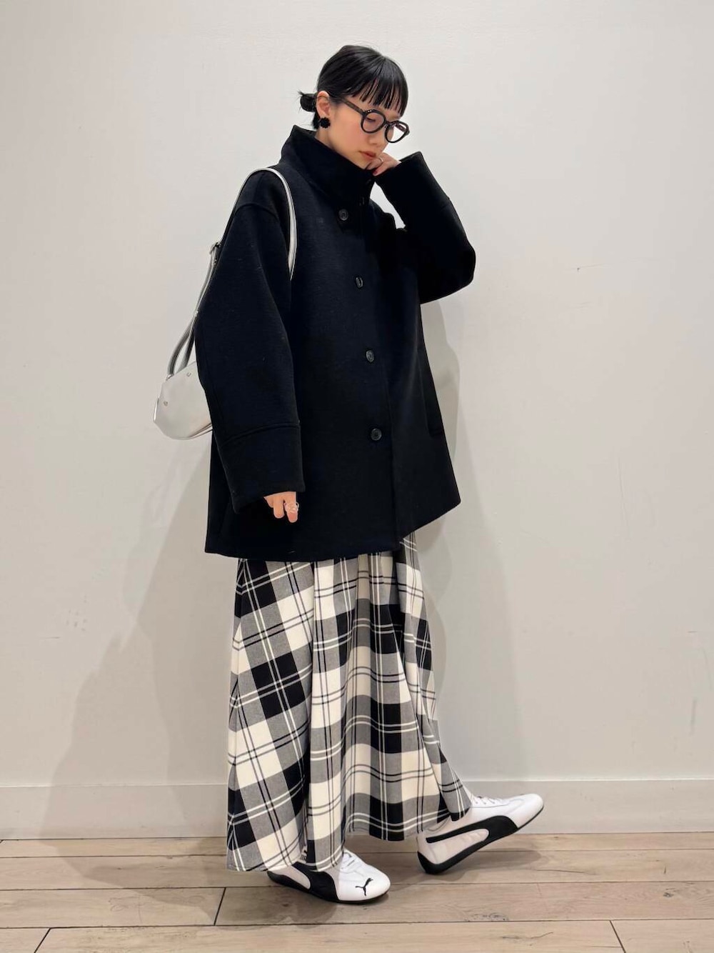 ブラック系のその他アウター、ホワイト系のスウェット、ホワイト系のスカートを着用したレディースの冬コーディネートの1枚目の写真