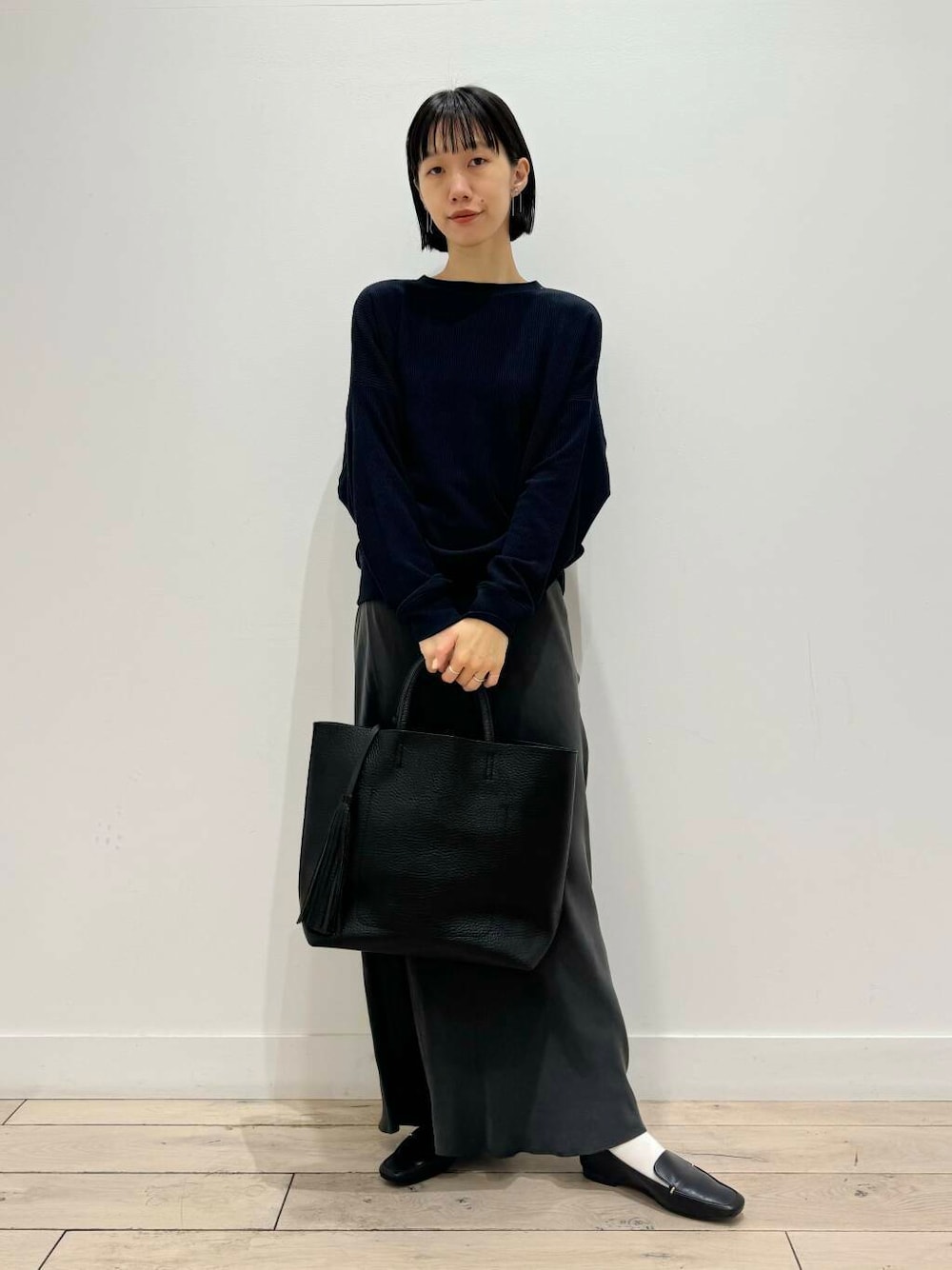 ブラック系のローファー、ブラック系のトートバッグ、ブルー系のTシャツ/カットソーを着用したレディースの夏コーディネートの1枚目の写真