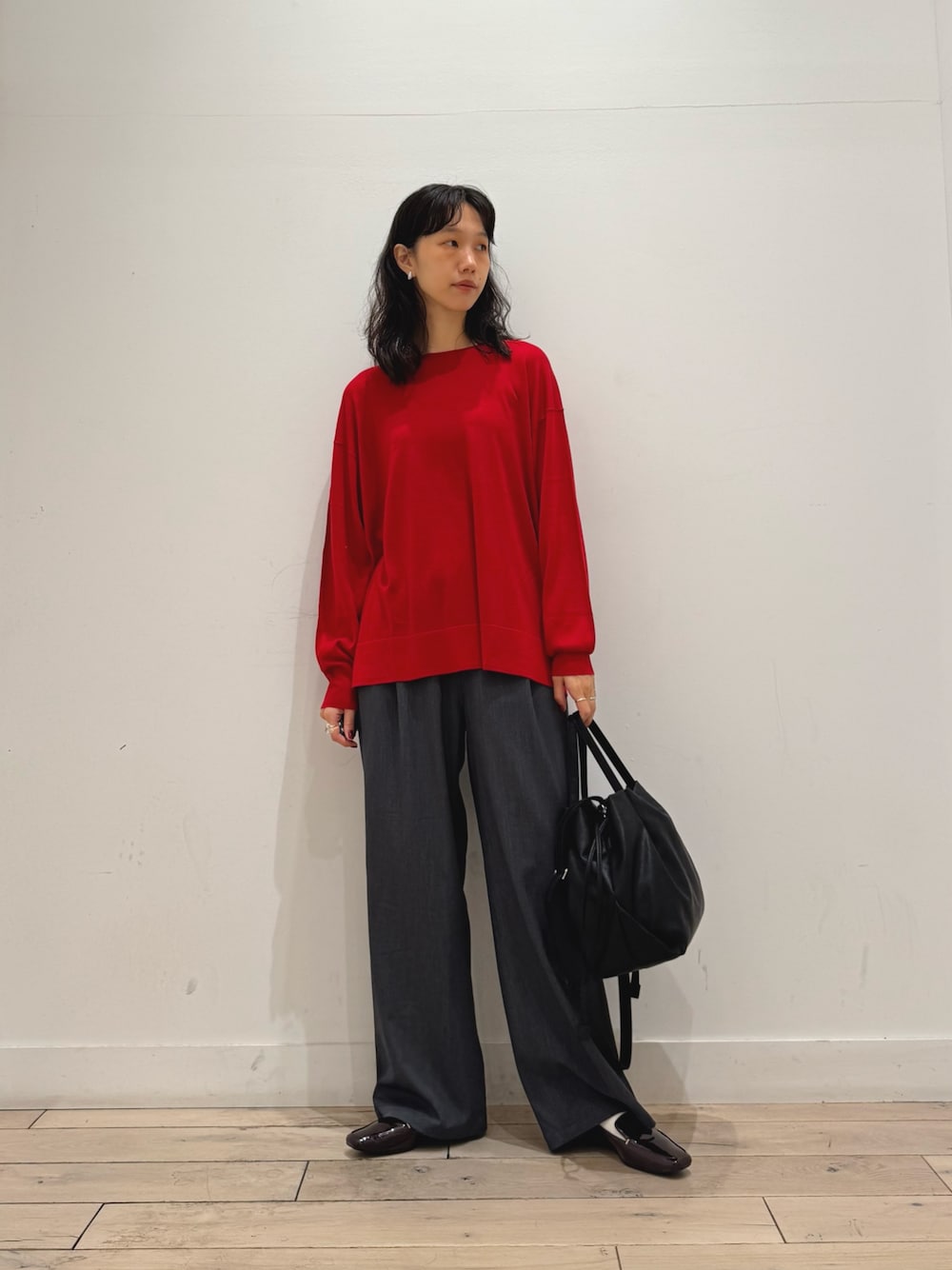 レッド系のニット/セーター、グレー系のその他パンツ、ブラウン系のローファーを着用したレディースの秋コーディネートの1枚目の写真