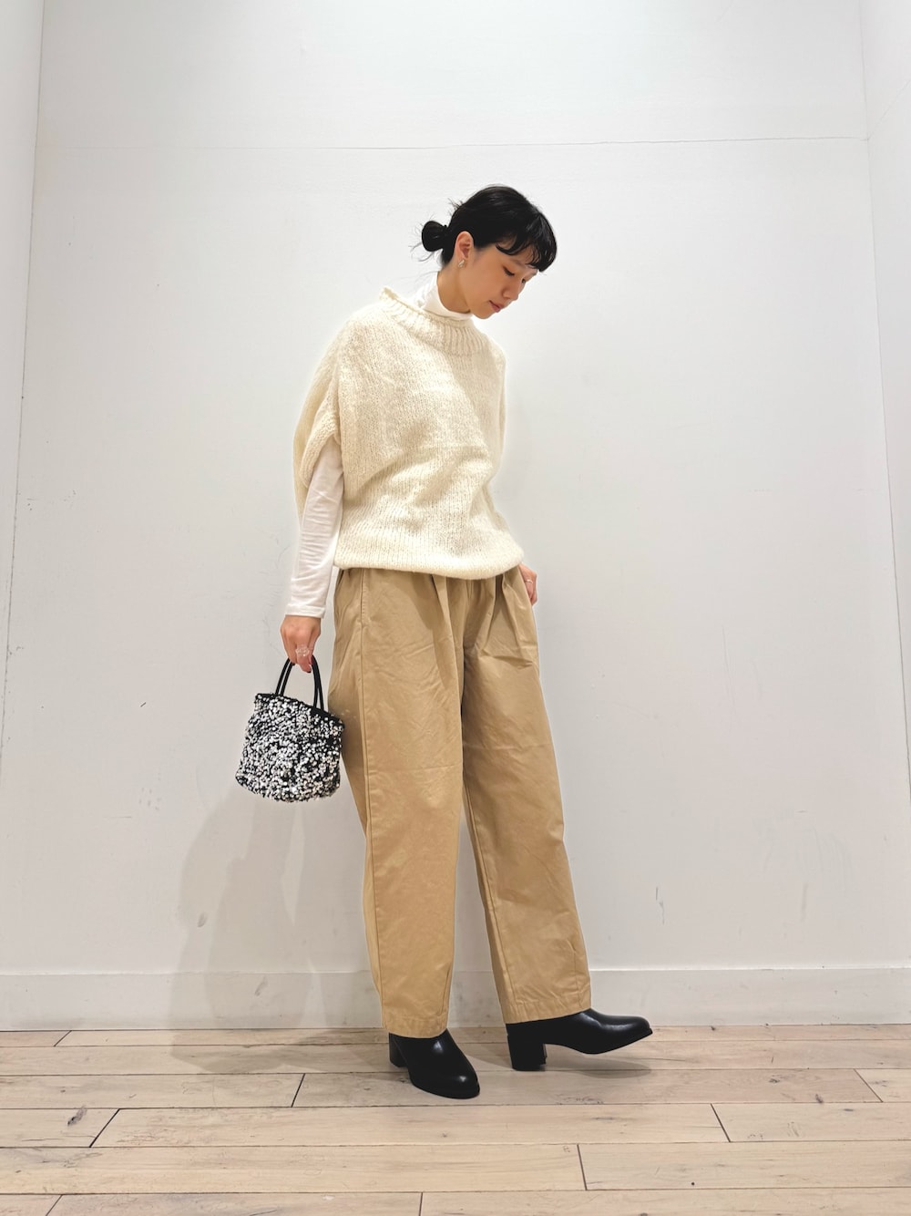 ホワイト系のTシャツ/カットソー、ホワイト系のニット/セーター、シルバー系のショルダーバッグを着用したレディースの秋コーディネートの1枚目の写真