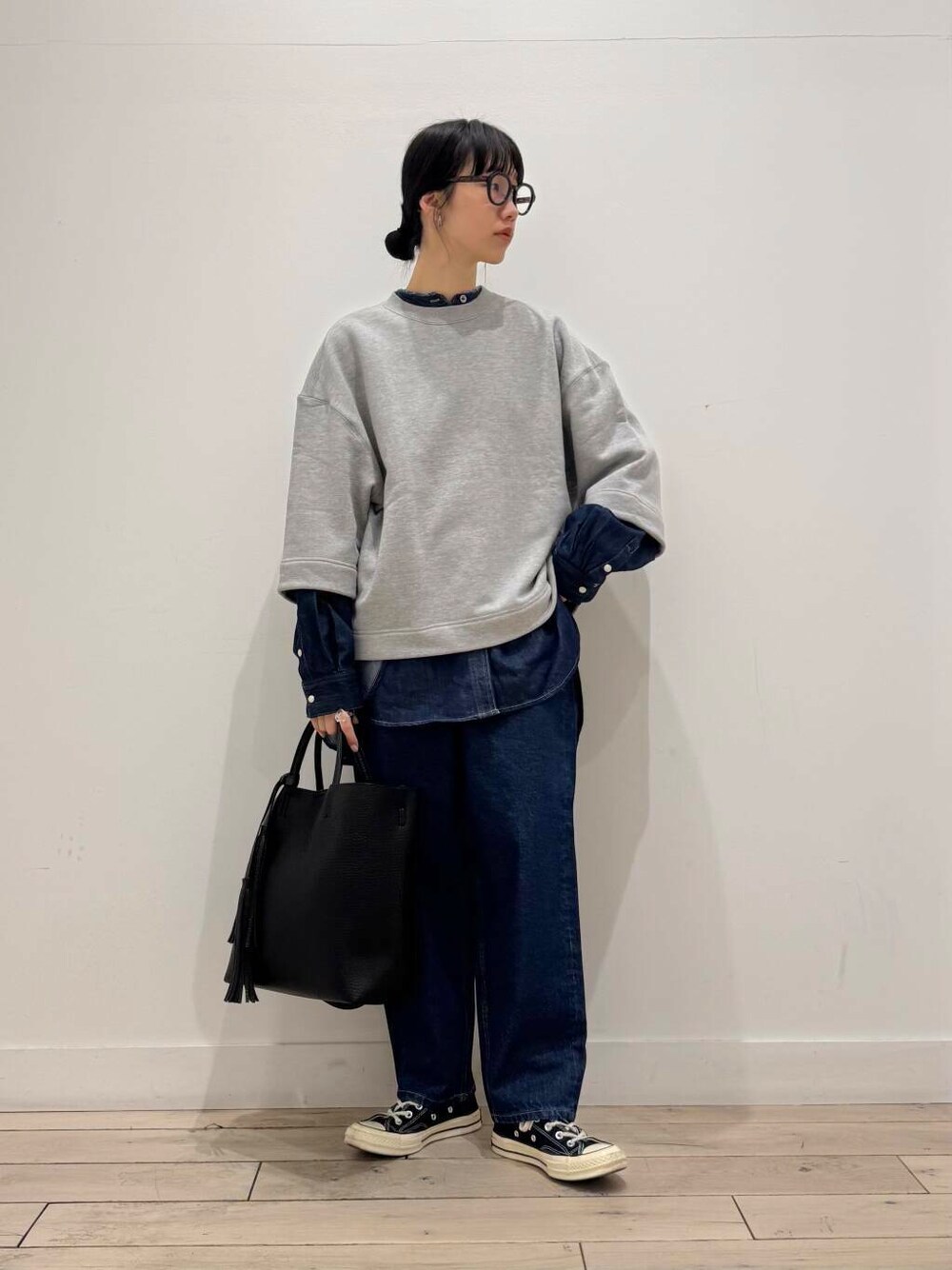 ブルー系のデニムパンツ、ブラック系のトートバッグ、ブルー系のシャツ/ブラウスを着用したレディースの春コーディネートの1枚目の写真