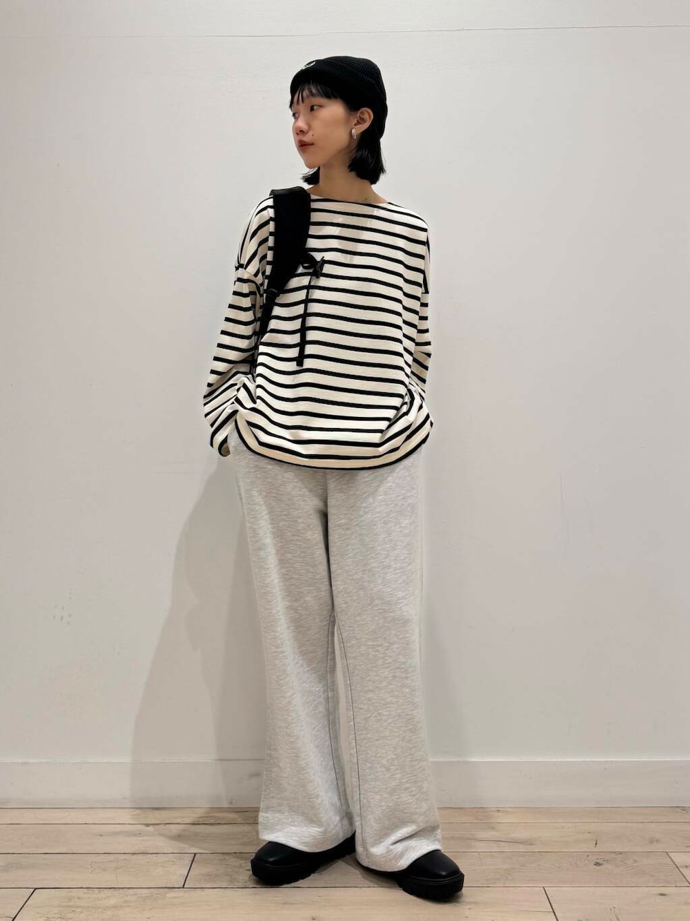 ブラック系のブーツ、ホワイト系のTシャツ/カットソー、ブラック系のバックパック/リュックを着用したレディースの秋コーディネートの1枚目の写真