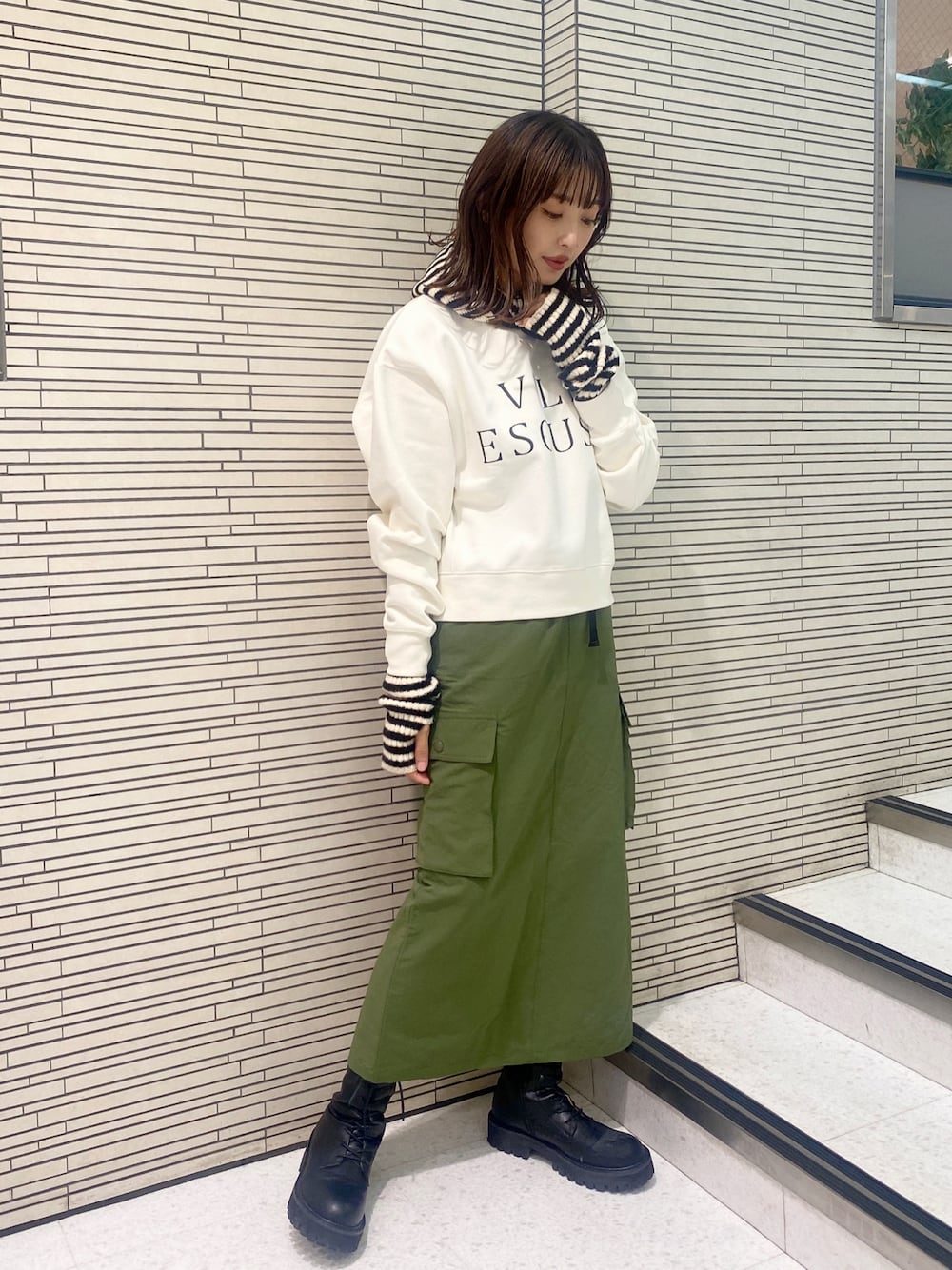 ホワイト系のスウェット、ブラック系のブーツ、その他のアームカバーを着用したレディースの秋コーディネートの1枚目の写真