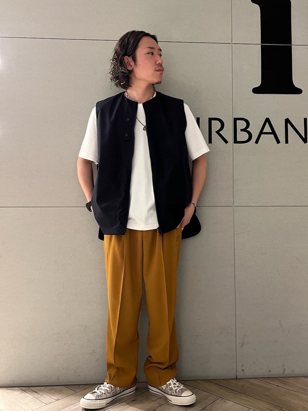 ホワイト系のTシャツ/カットソー、オレンジ系のスラックス、その他のスニーカーを着用したメンズの春コーディネートの1枚目の写真