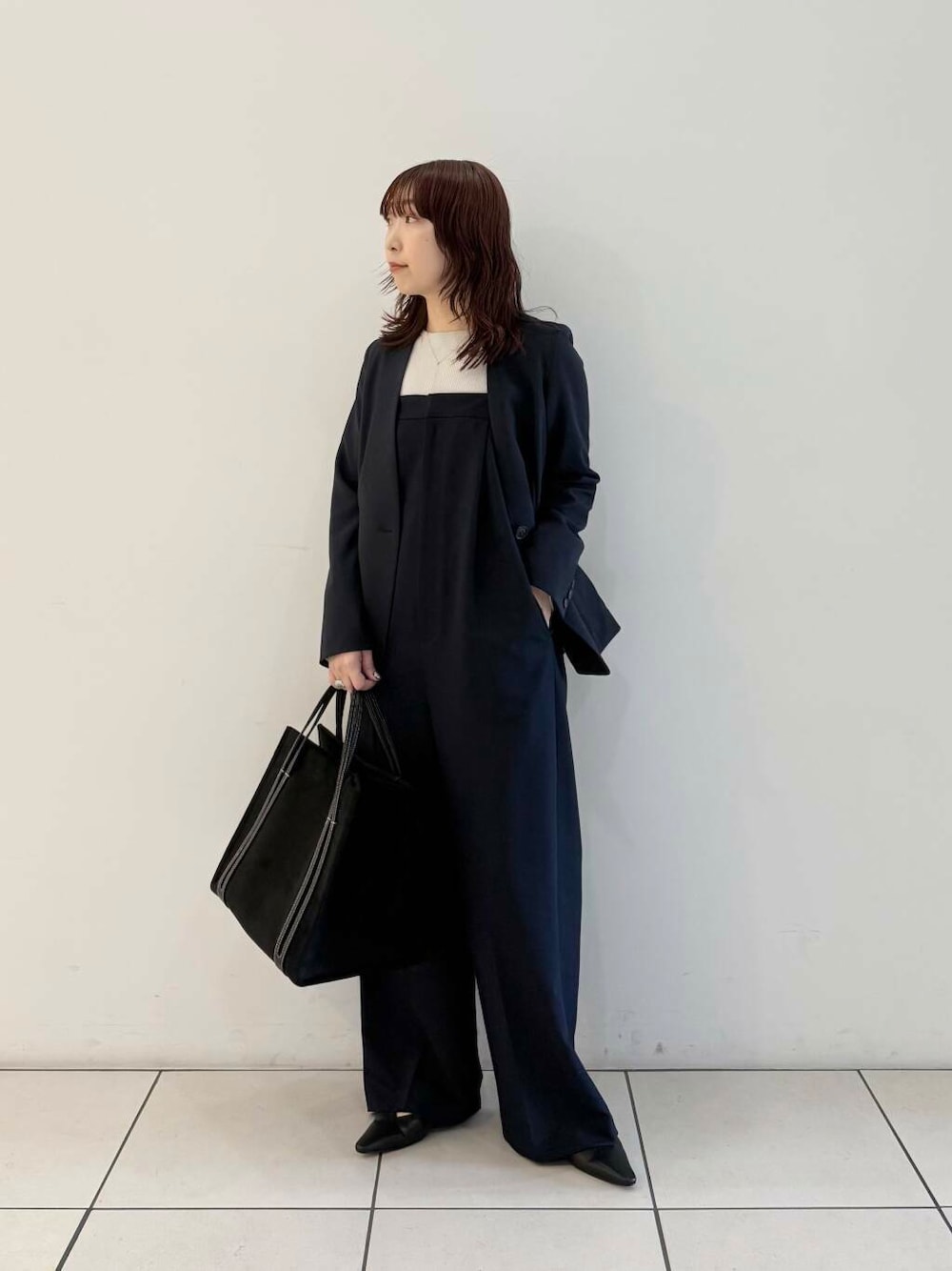 ブルー系のノーカラージャケット、ブルー系のサロペット/オーバーオール、グレー系のニット/セーターを着用したレディースの春コーディネートの1枚目の写真