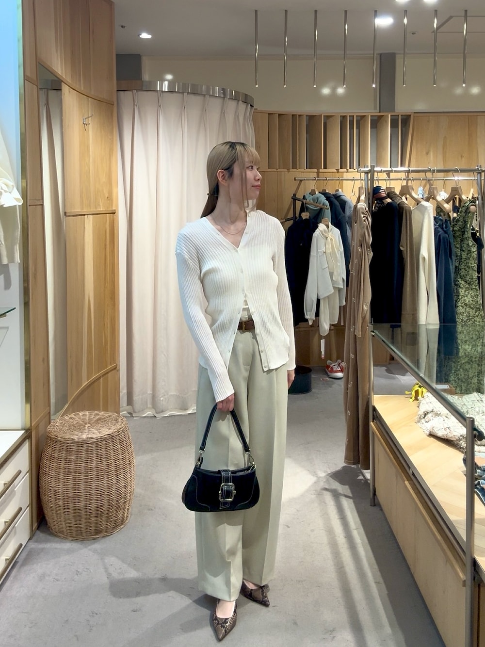 ホワイト系のカーディガン/ボレロ、ベージュ系のその他パンツ、ブラック系のハンドバッグを着用したレディースの春コーディネートの1枚目の写真