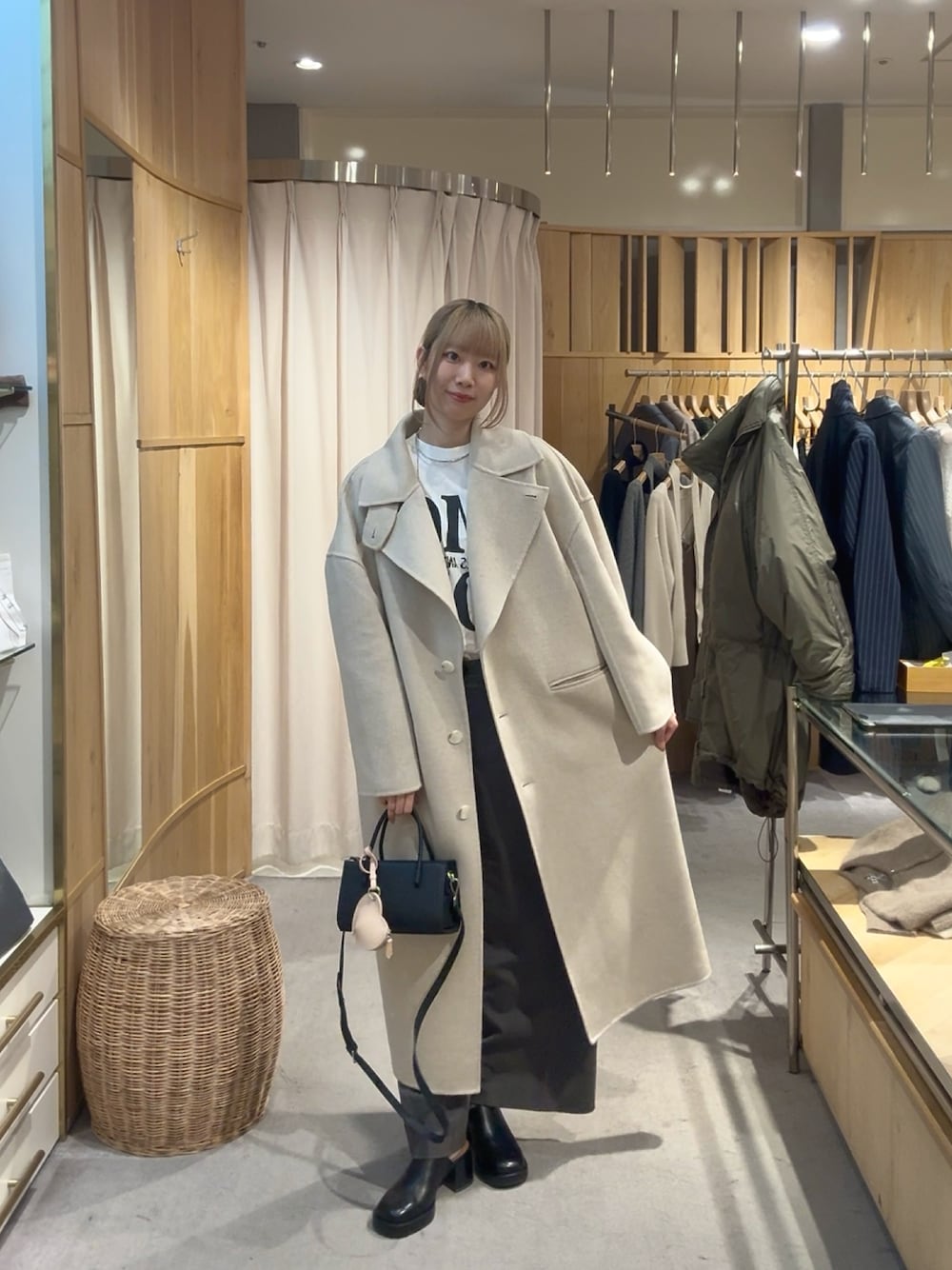 ホワイト系のその他アウター、ブラック系のトートバッグ、ホワイト系のTシャツ/カットソーを着用したレディースの冬コーディネートの1枚目の写真