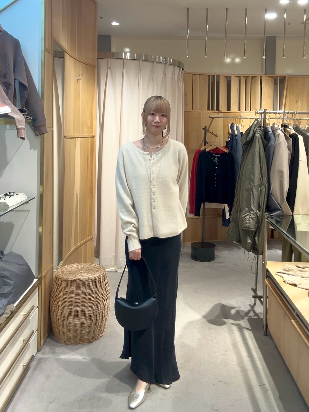 ホワイト系のカーディガン/ボレロ、ブラック系のトートバッグ、ブラック系のスカートを着用したレディースの秋コーディネートの1枚目の写真