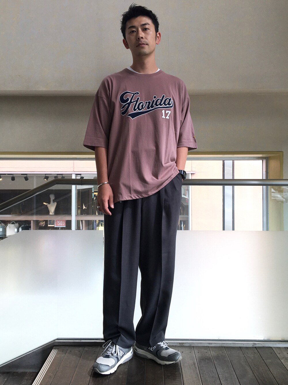 ピンク系のTシャツ/カットソー、グレー系のスラックスを着用したメンズの夏コーディネートの1枚目の写真