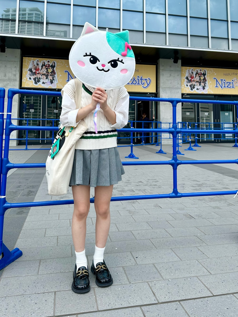 ブラック系のローファー、グレー系のスカート、ブラック系のトートバッグを着用したキッズの春コーディネートの1枚目の写真