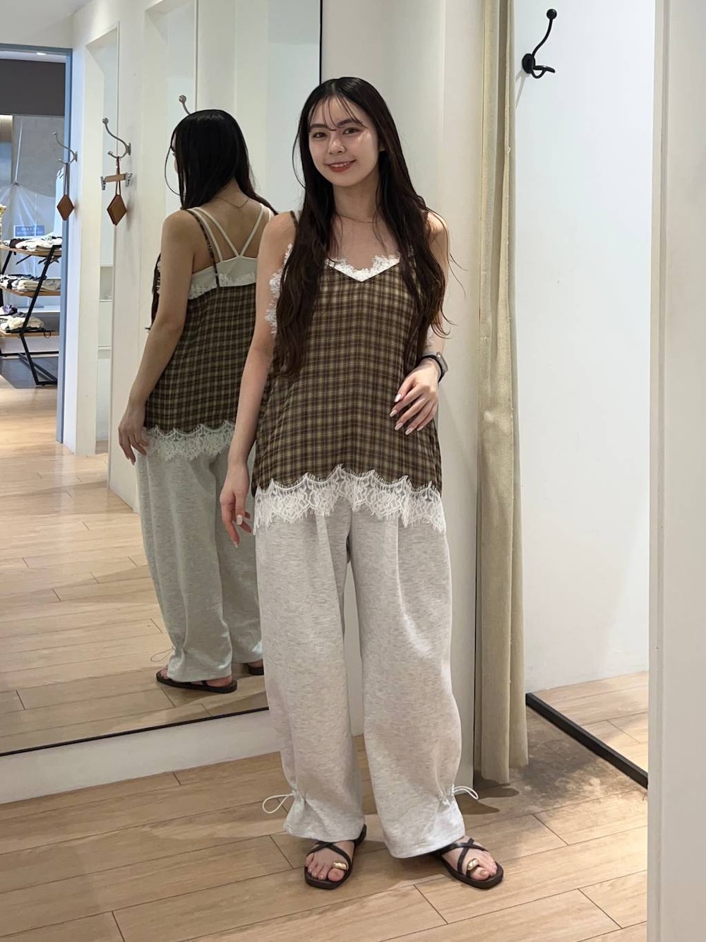 ホワイト系のTシャツ/カットソー、ブラウン系のサンダル、グレー系のスウェットパンツを着用したレディースの夏コーディネートの1枚目の写真