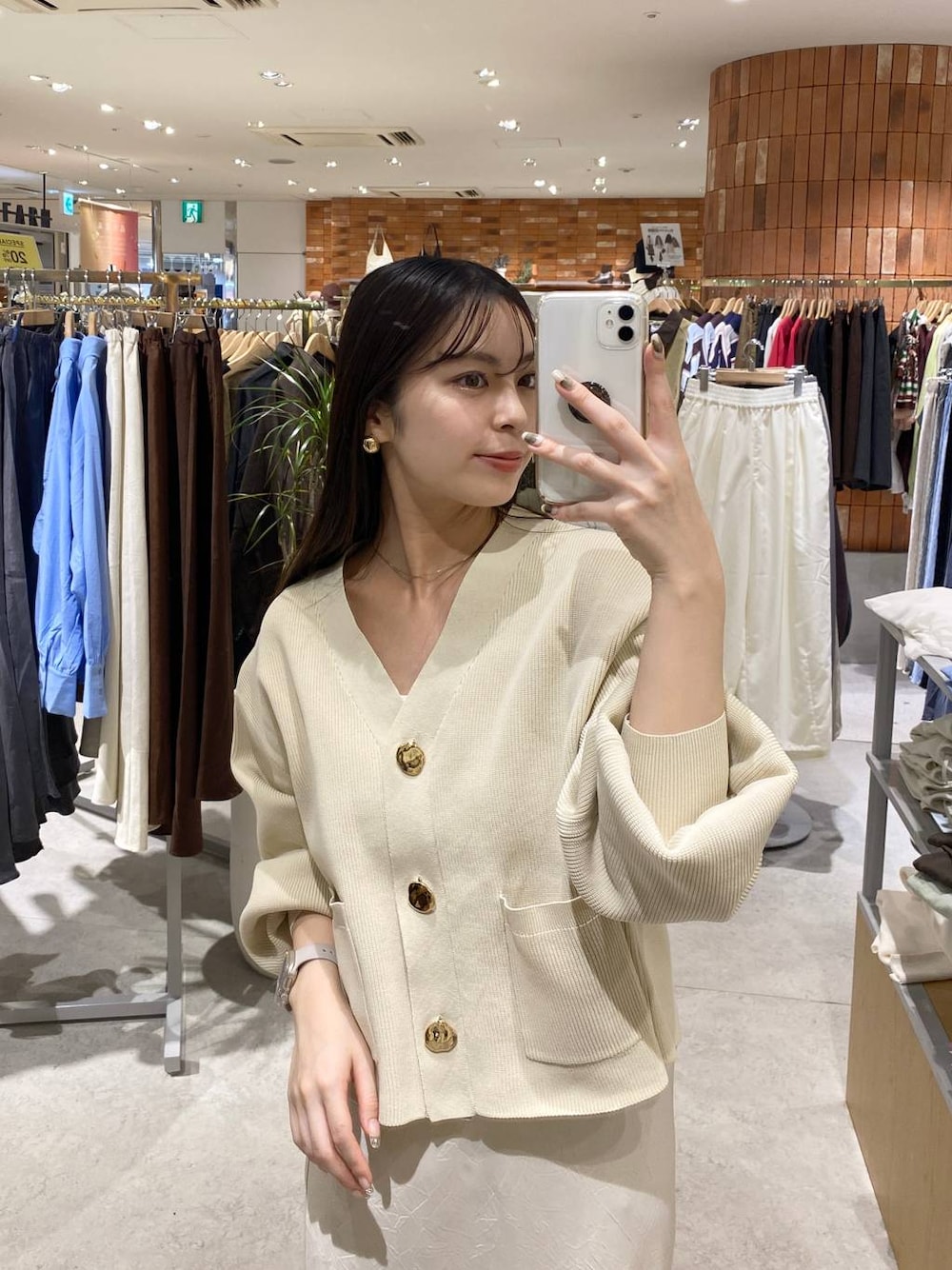 ホワイト系のスカート、ホワイト系のカーディガン/ボレロ、ブラウン系のローファーを着用したレディースの秋コーディネートの1枚目の写真