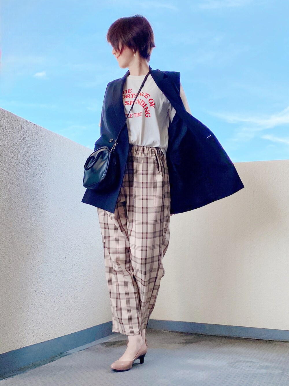 ホワイト系のTシャツ/カットソー、ブラック系のベスト、ブラック系のショルダーバッグを着用したレディースの秋コーディネートの1枚目の写真
