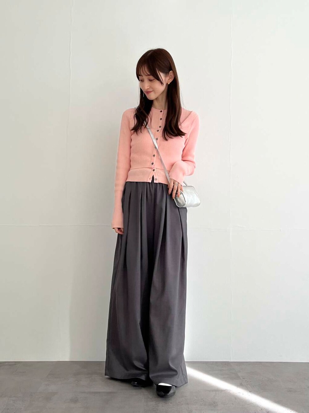 グレー系のその他パンツ、シルバー系のショルダーバッグ、ピンク系のベストを着用したレディースの冬コーディネートの1枚目の写真