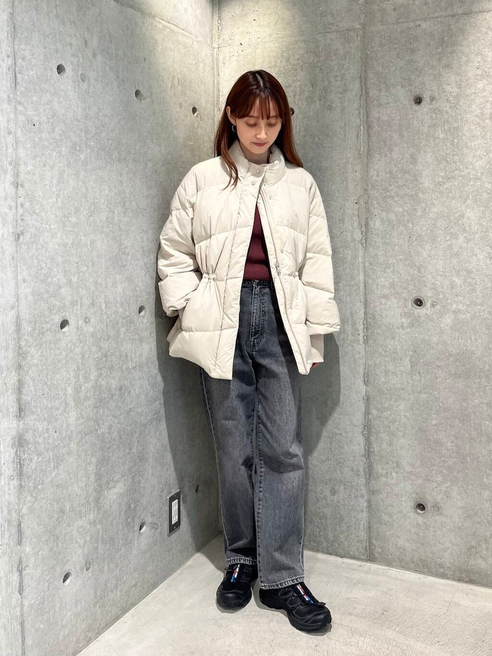 ブラック系のデニムパンツ、ブラック系のスニーカー、ホワイト系のダウンジャケット/コートを着用したレディースの秋コーディネートの1枚目の写真