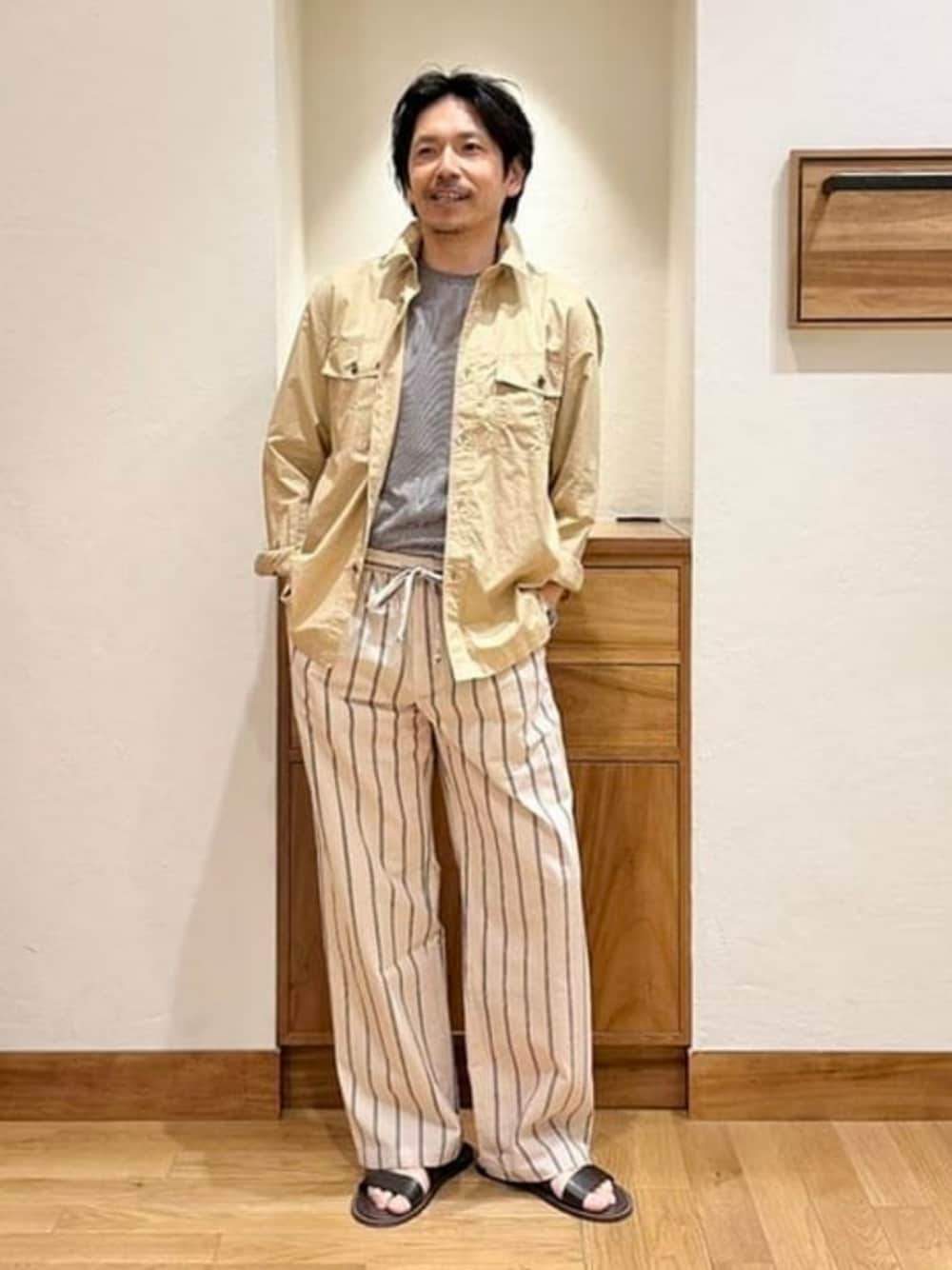 ブルー系のTシャツ/カットソー、ブラウン系のサンダル、ベージュ系のシャツ/ブラウスを着用したメンズの夏コーディネートの1枚目の写真