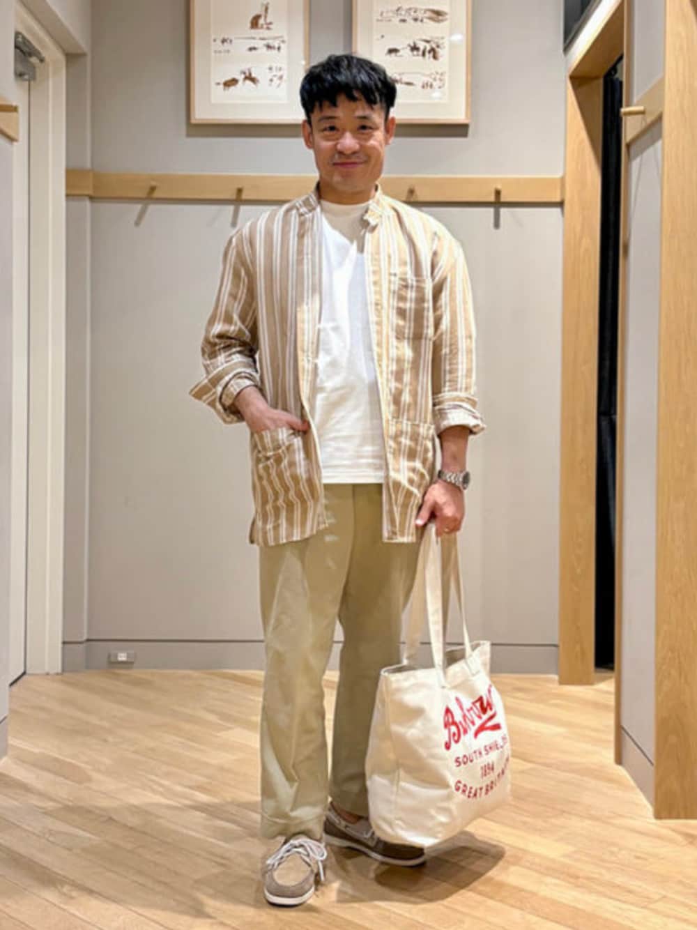 ホワイト系のTシャツ/カットソー、ベージュ系のその他アウター、レッド系のトートバッグを着用したメンズの春コーディネートの1枚目の写真