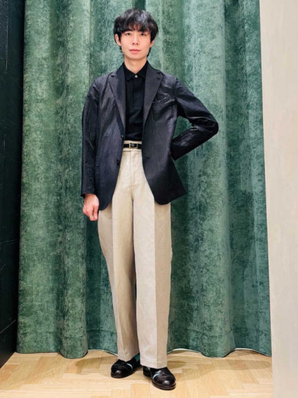 ブラック系のポロシャツを着用したメンズの春コーディネートの1枚目の写真