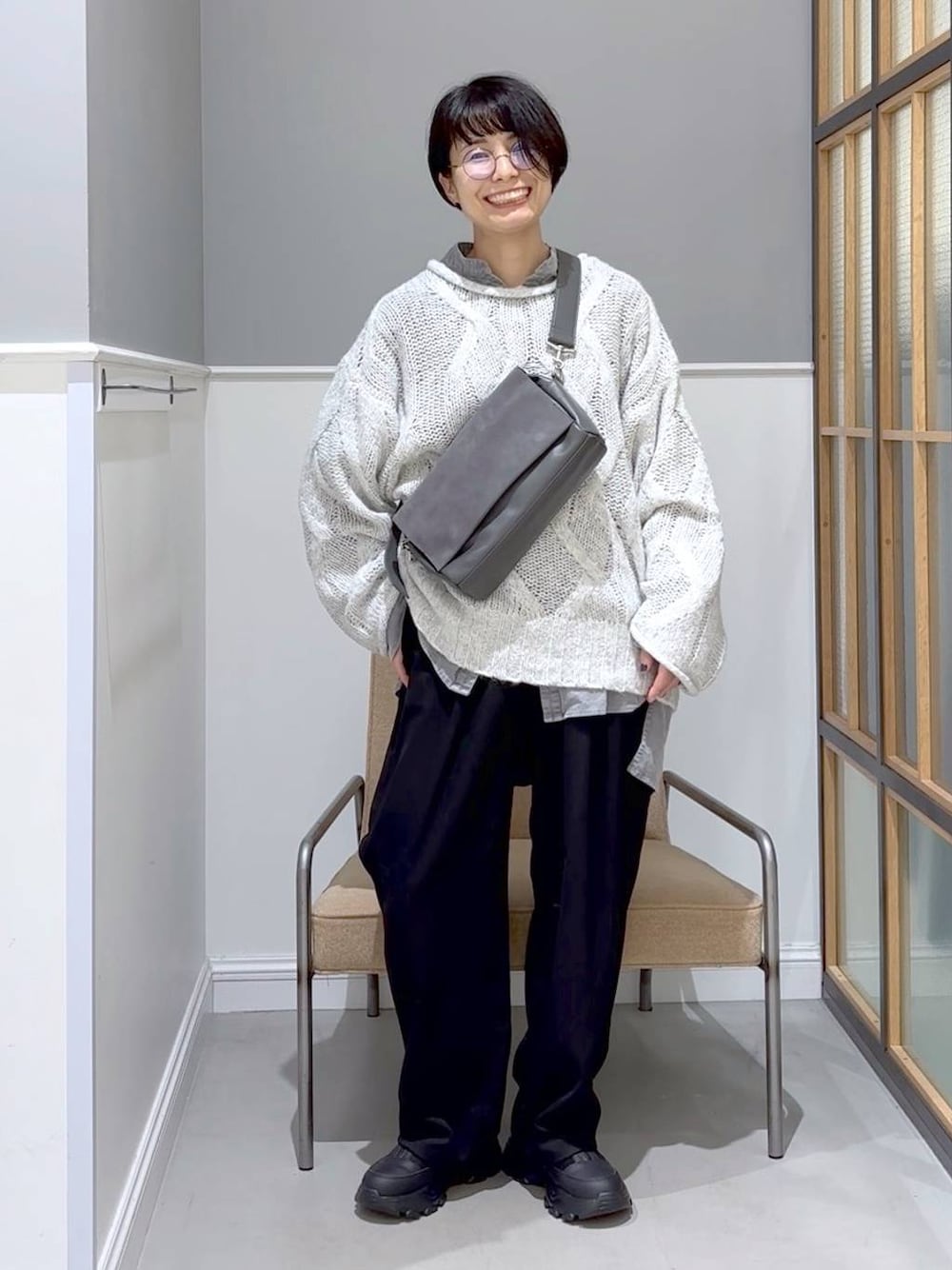 グレー系のショルダーバッグ、ブラック系のその他パンツ、グレー系のニット/セーターを着用したレディースの秋コーディネートの1枚目の写真