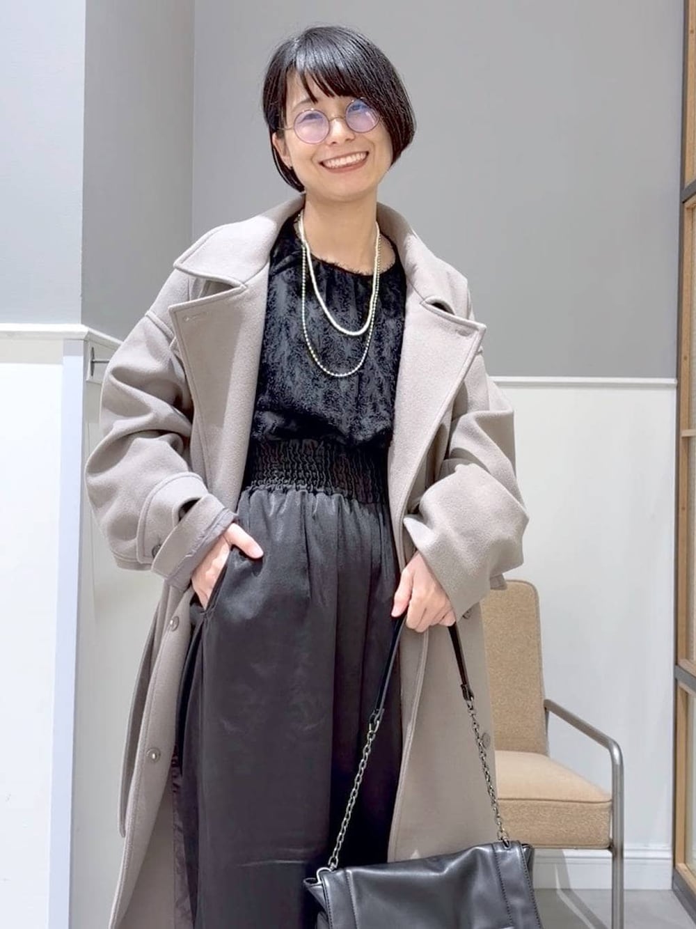 ブラウン系のステンカラーコート、ブラック系のTシャツ/カットソー、ブラック系のその他パンツを着用したレディースの冬コーディネートの1枚目の写真