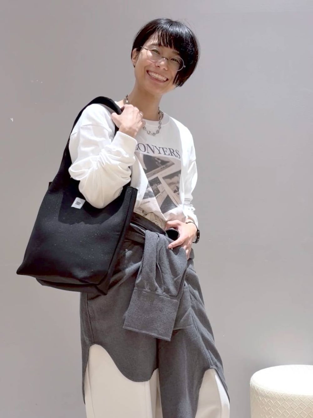 グレー系のシャツ/ブラウス、ブラック系のトートバッグ、ブラック系のスニーカーを着用したレディースの秋コーディネートの1枚目の写真