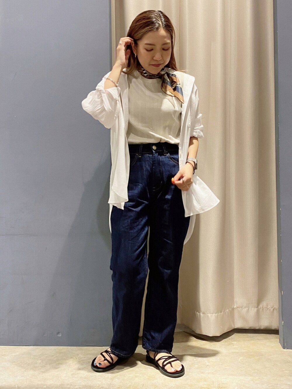 ブラック系のサンダル、ブルー系のデニムパンツ、ベージュ系のTシャツ/カットソーを着用したレディースの秋コーディネートの1枚目の写真