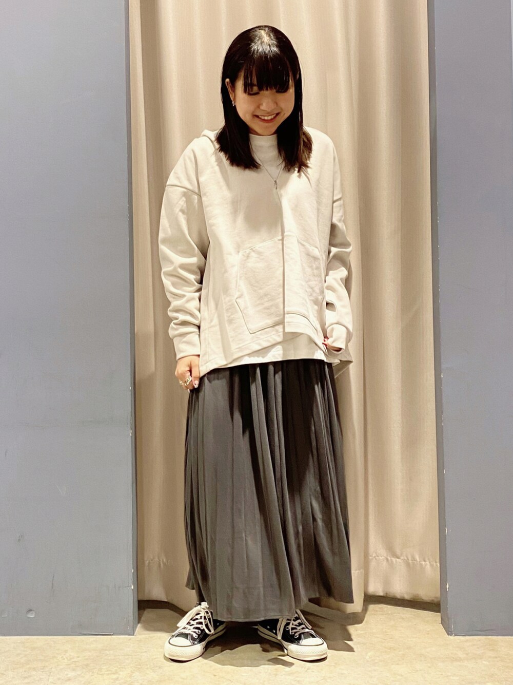 ブラック系のスニーカー、グレー系のスカート、グレー系のTシャツ/カットソーを着用したレディースの秋コーディネートの1枚目の写真