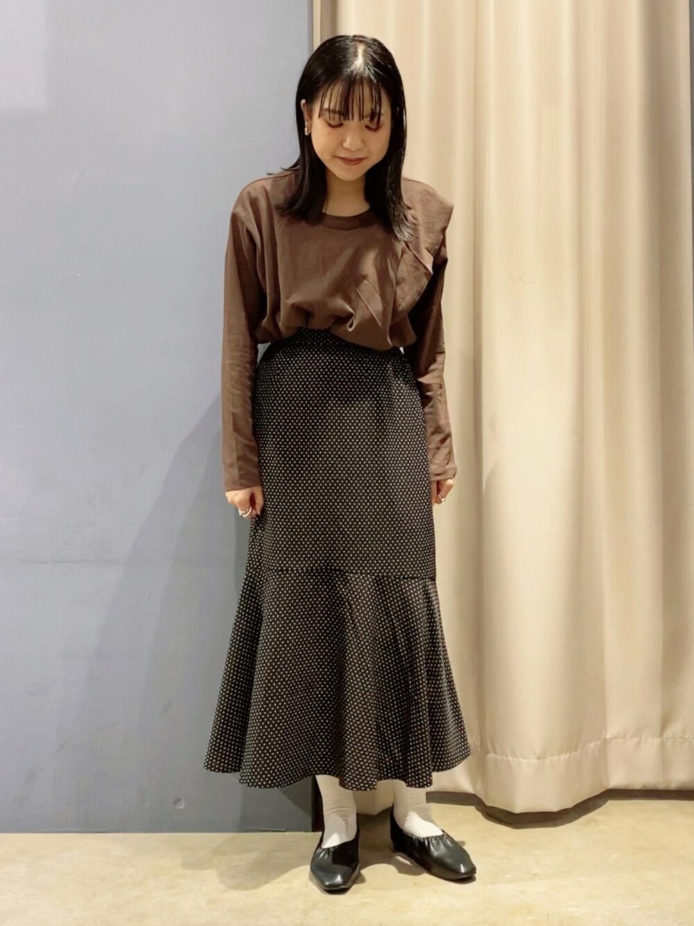 ブラック系のパンプス、ブラウン系のTシャツ/カットソー、その他のスカートを着用したレディースの秋コーディネートの1枚目の写真
