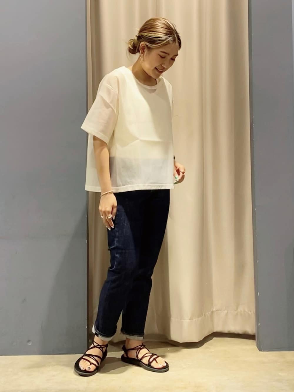 ブラック系のサンダル、ホワイト系のTシャツ/カットソー、ブルー系のデニムパンツを着用したレディースの夏コーディネートの1枚目の写真
