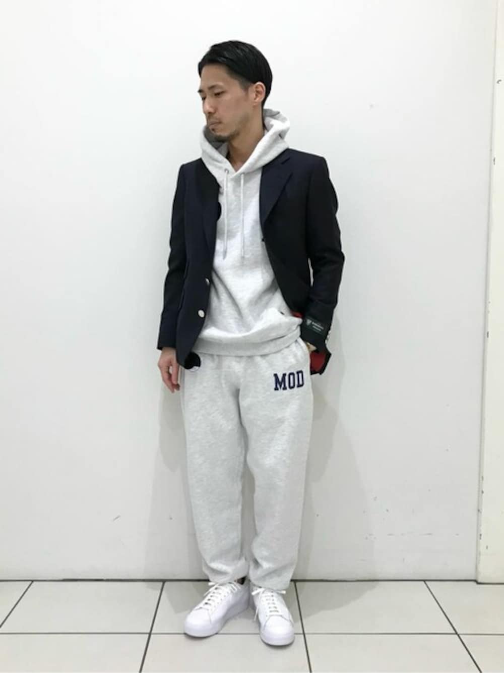 グレー系のパーカー、グレー系のスウェットパンツ、ブルー系のテーラードジャケットを着用したメンズの冬コーディネートの1枚目の写真