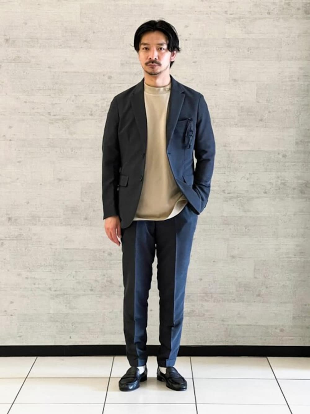 ブルー系のテーラードジャケット、ブルー系のスラックス、イエロー系のTシャツ/カットソーを着用したメンズの春コーディネートの1枚目の写真