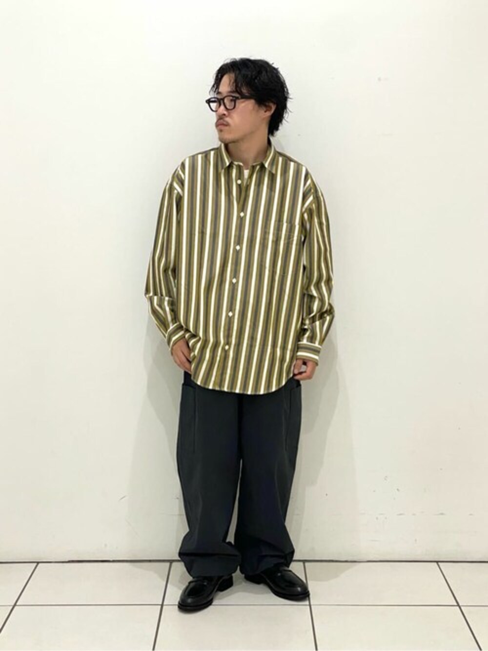イエロー系のシャツ/ブラウス、グレー系のその他パンツ、ブラック系のローファーを着用したメンズの秋コーディネートの1枚目の写真